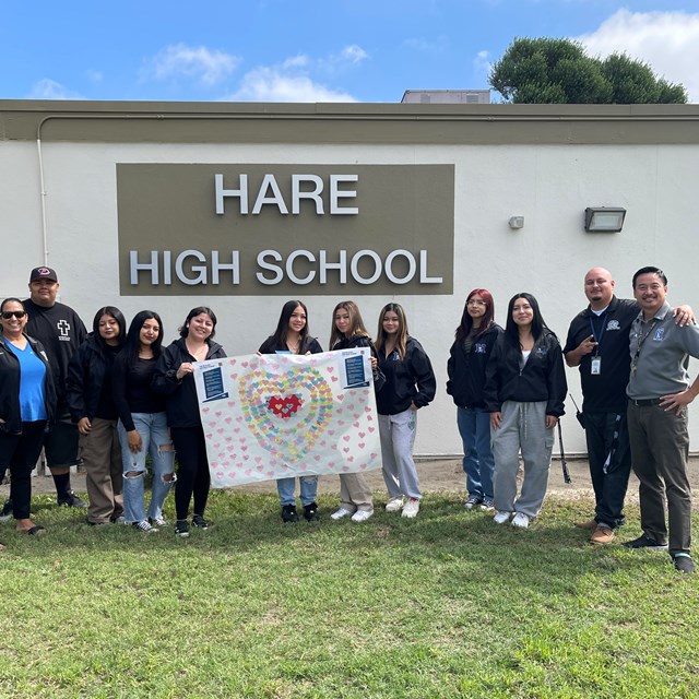 Hare students presenting a "No Place For Hate Pledge" banner signed by Hare students and staff